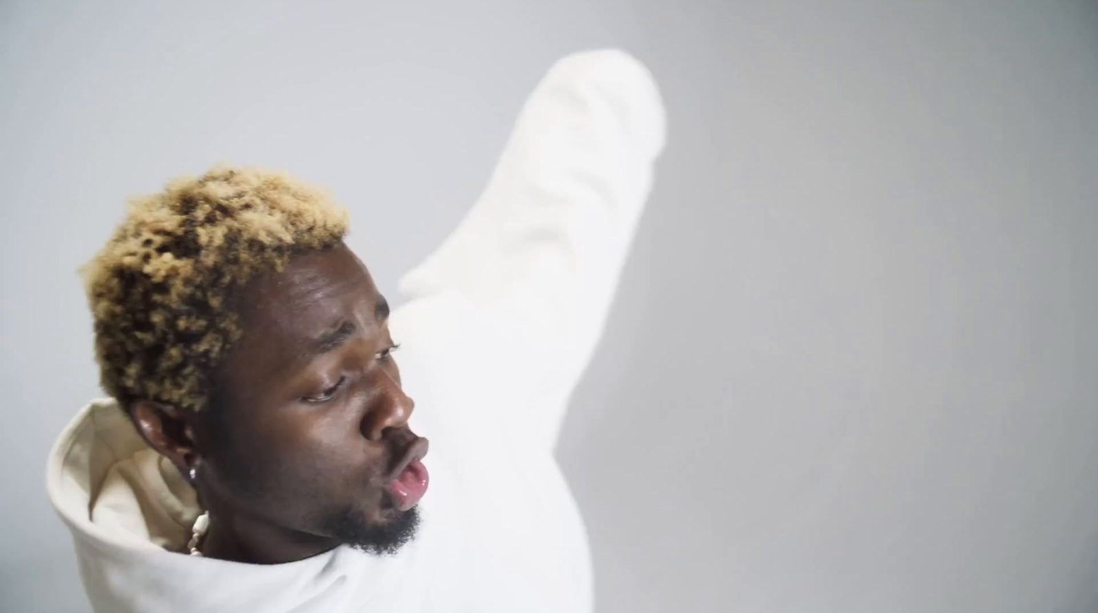 a man with his mouth open wearing a white hoodie