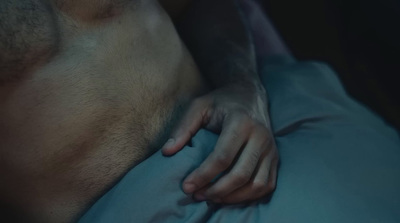 a man laying in bed with his hand on his stomach