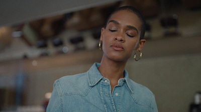 a woman in a denim shirt looking at her cell phone