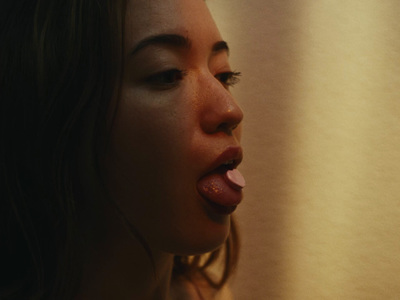 a woman sticking her tongue out in front of a curtain