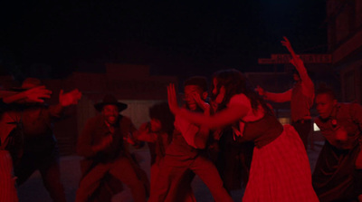 a group of people dancing on a street at night