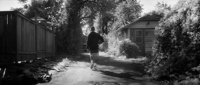 a black and white photo of a man walking down a path