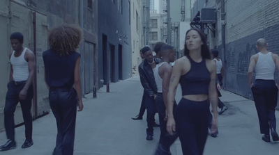 a group of people walking down a street next to tall buildings