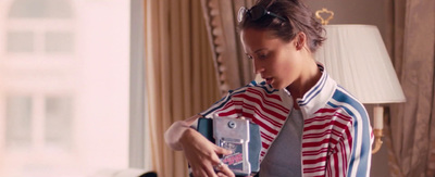 a woman in a red, white and blue jacket holding a cell phone