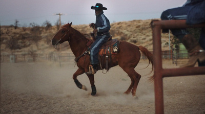 a man riding on the back of a brown horse