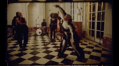 a group of people in a room with a black and white checkered floor