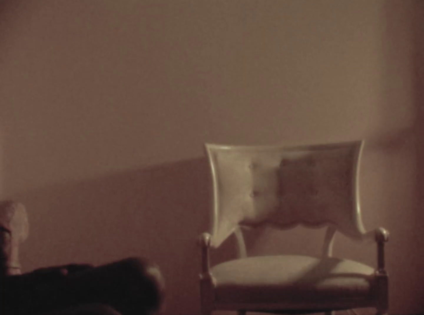 a white chair sitting in a room next to a window