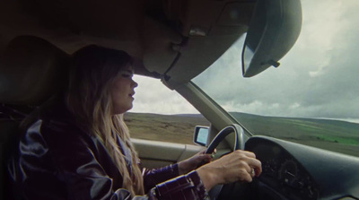 a woman driving a car on a cloudy day