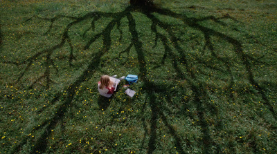 a young girl sitting in a field with a frisbee