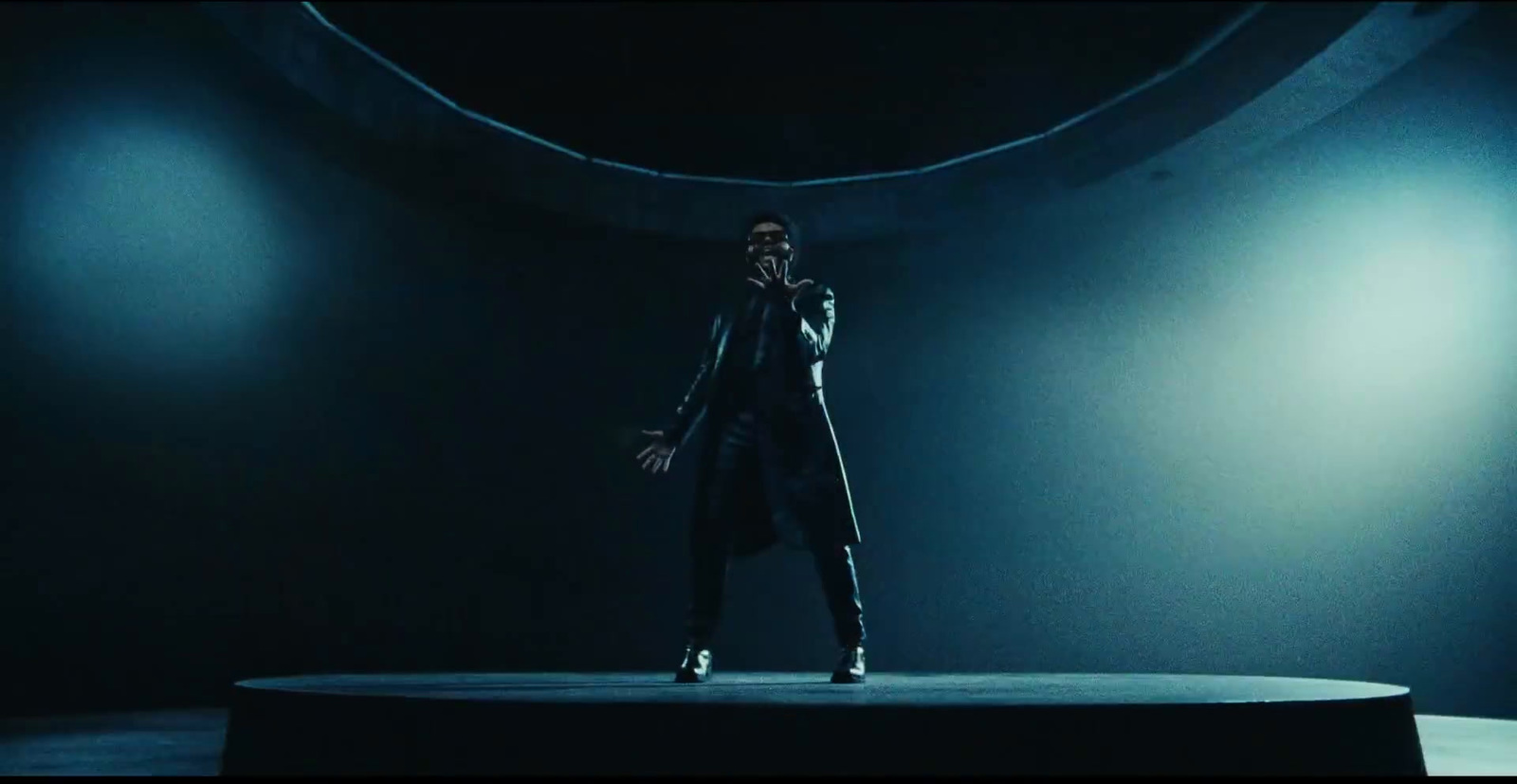 a man standing on top of a stage in a dark room