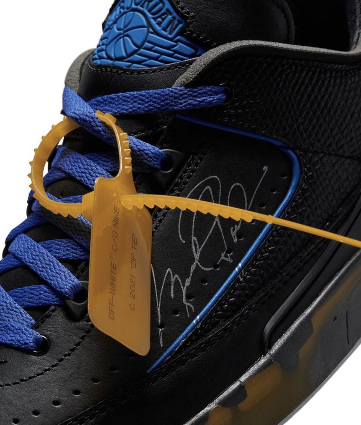 a pair of black and blue sneakers with a yellow tag