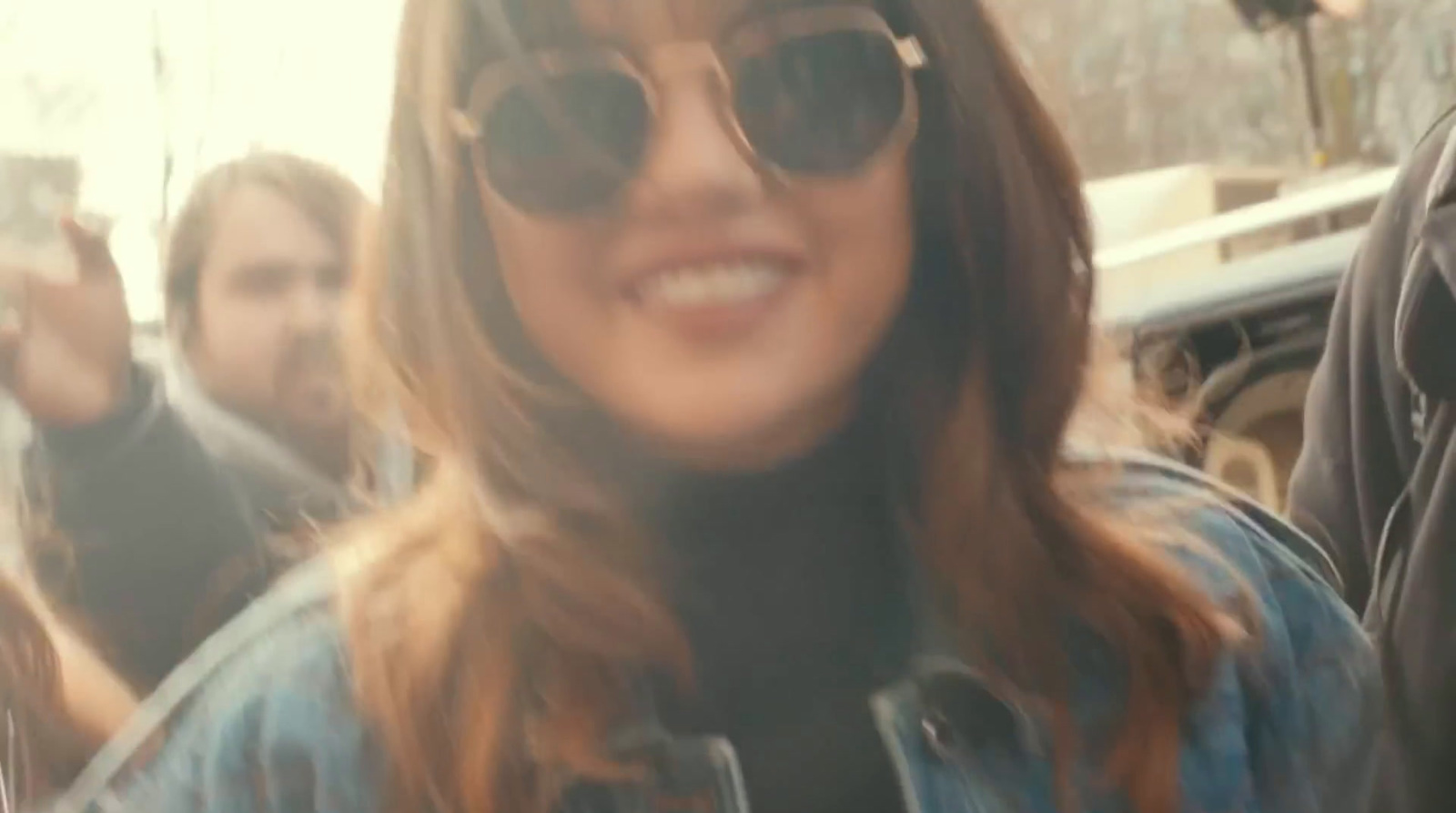 a woman wearing sunglasses and a denim jacket