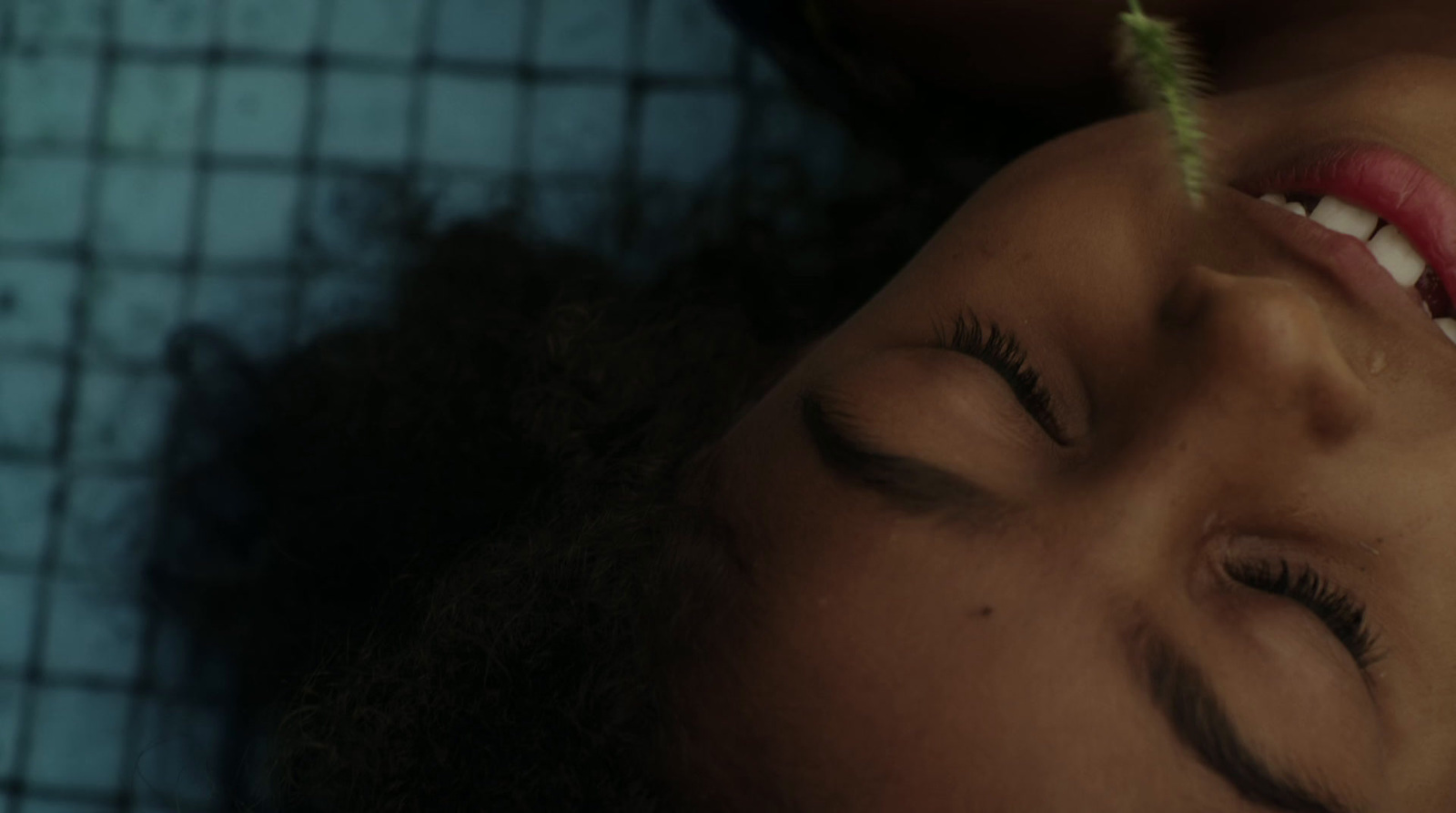 a close up of a person laying down with a flower in their hair