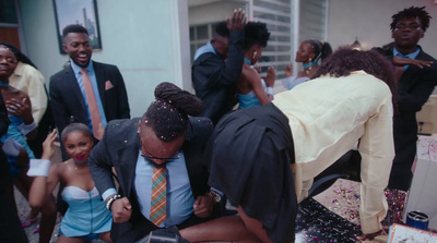 a group of people standing around a woman cutting a cake