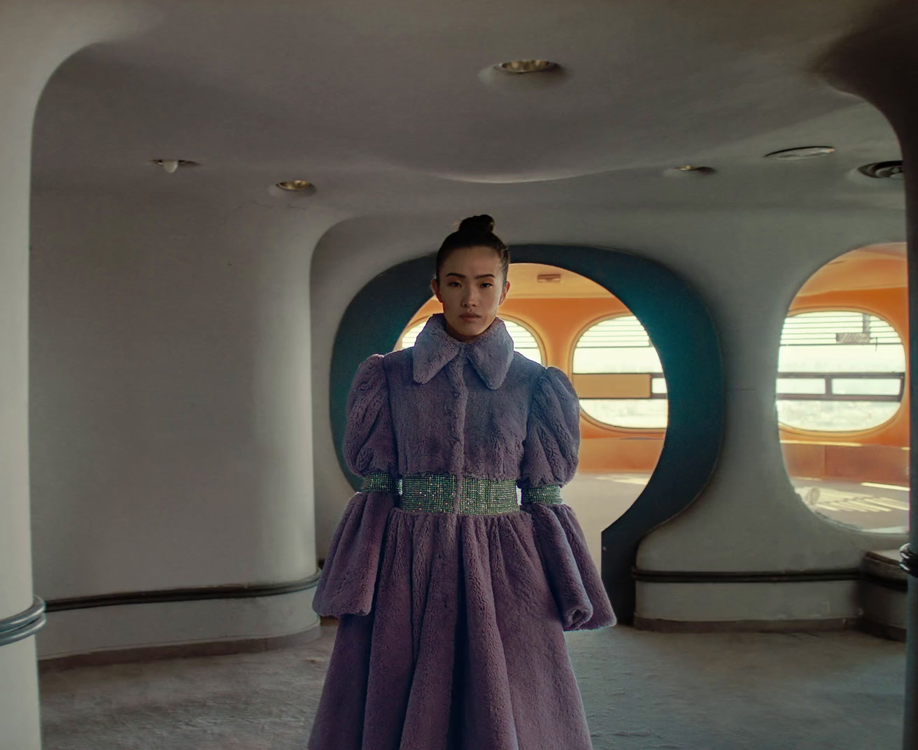 a woman in a purple dress standing in a room