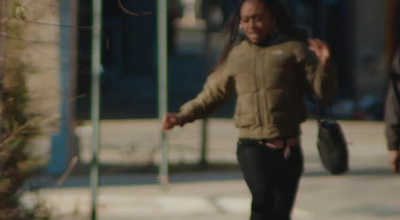 a man walking down a street holding a frisbee