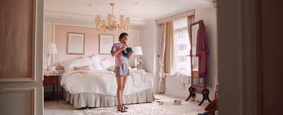 a woman standing in a bedroom next to a bed