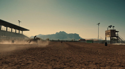 a person riding a horse on a dirt track