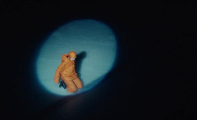 a small teddy bear sitting in a dark room