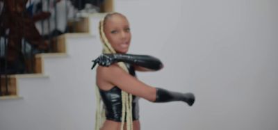 a doll is dressed in black leather and has long blonde hair