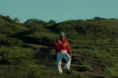 a man in a red jacket is walking up a hill