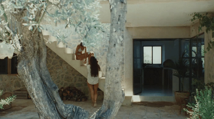 a couple of women standing next to a tree