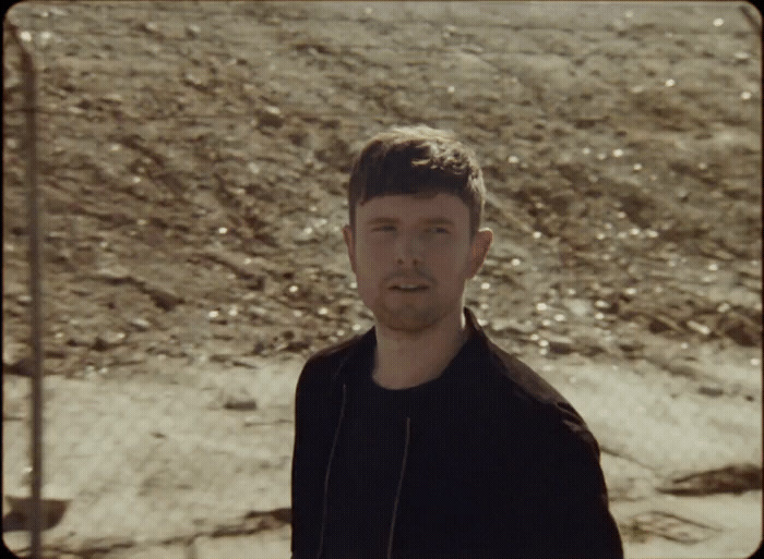 a man standing in front of a dirt hill