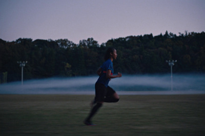 a person running in a field with a lot of fog