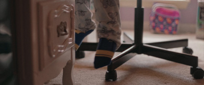 the legs of a person standing in front of a desk