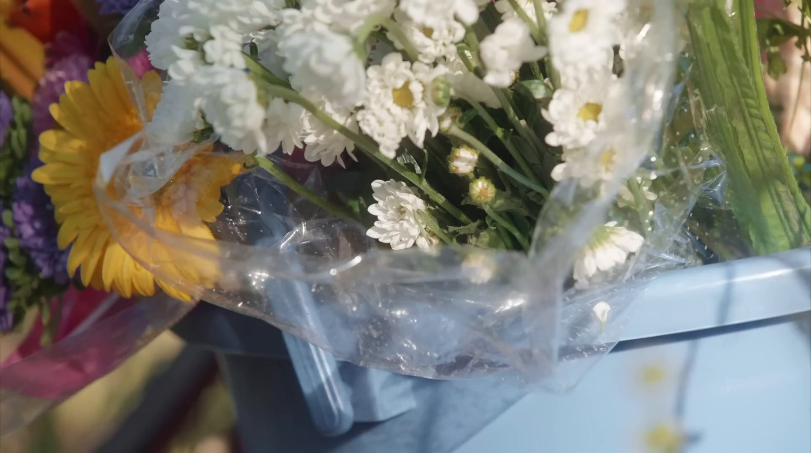 a bouquet of white and yellow flowers in a plastic bag