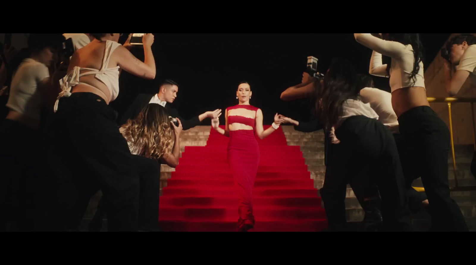 a woman in a red dress walking down a red carpet