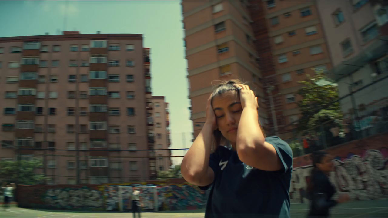 a woman walking down a street while holding her head in her hands