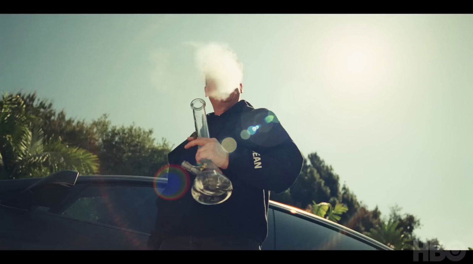 a man smoking a pipe next to a car