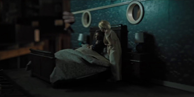 a doll sitting on top of a bed in a room