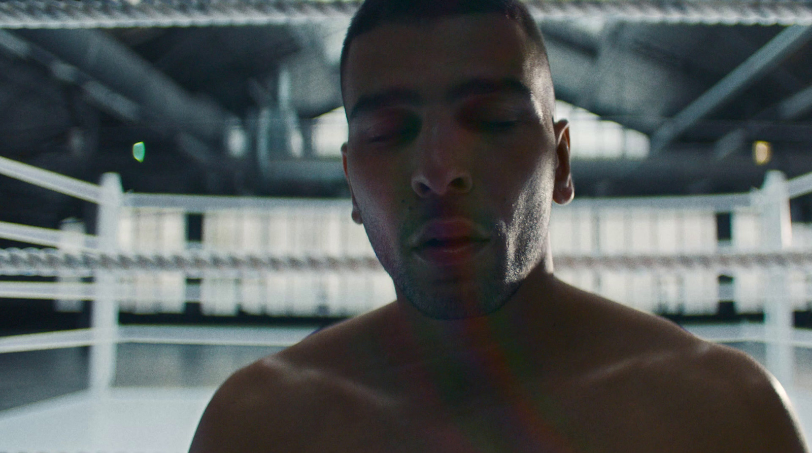 a man standing in a boxing ring with his eyes closed