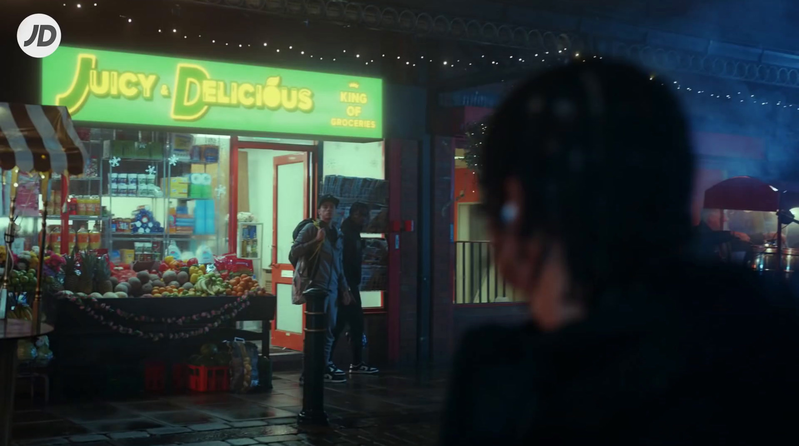 a man standing in front of a store at night