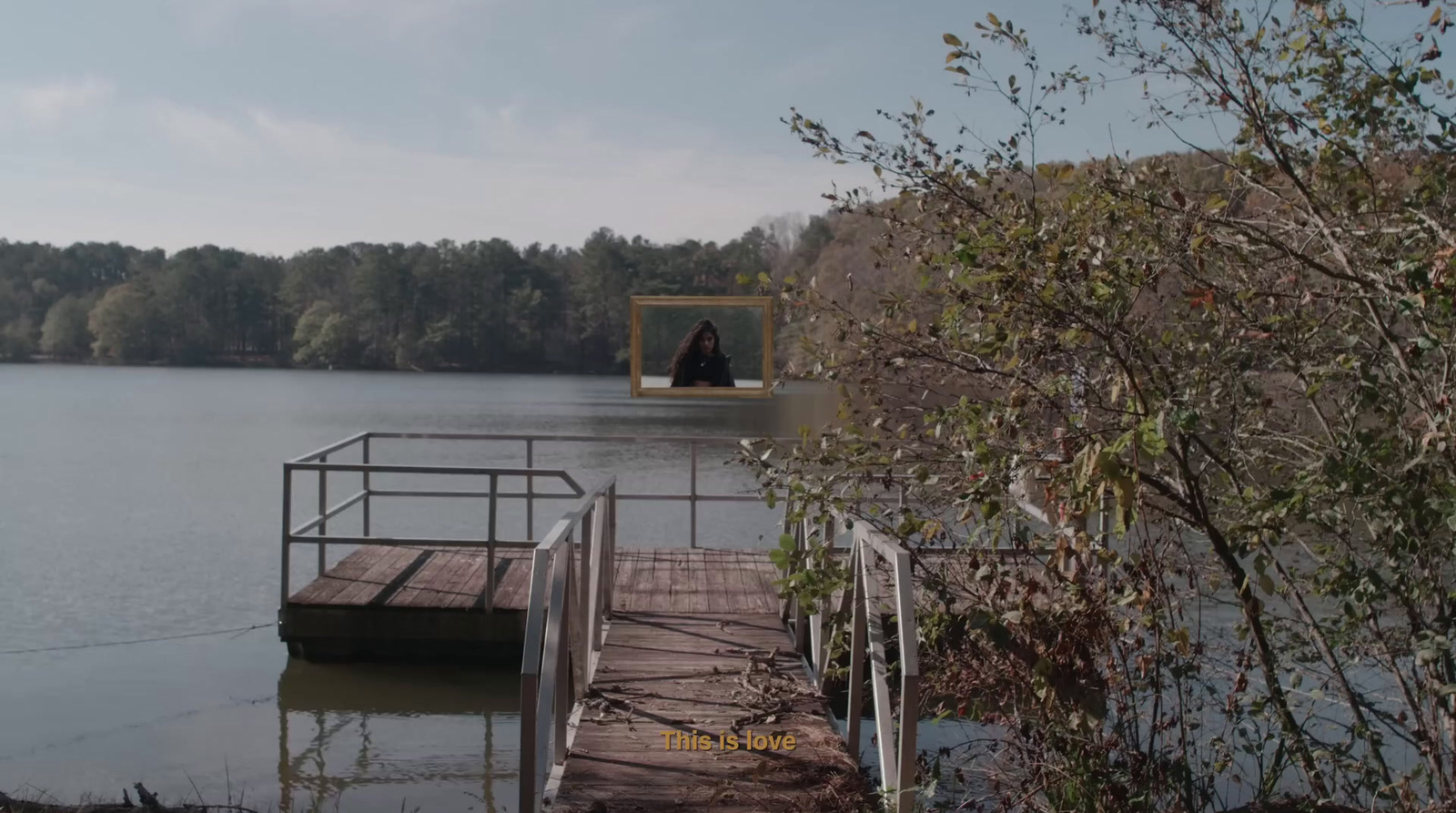 a person standing on a dock near a body of water