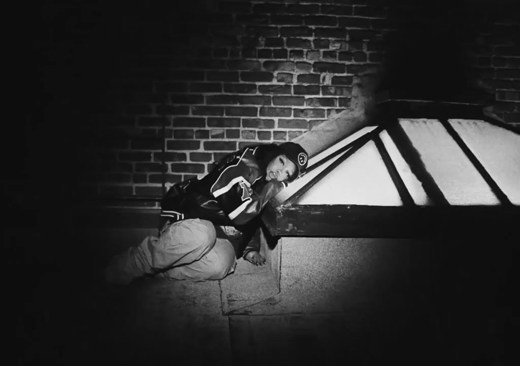 a man kneeling down next to a brick wall