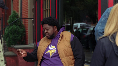 a man in a vest looking at his cell phone