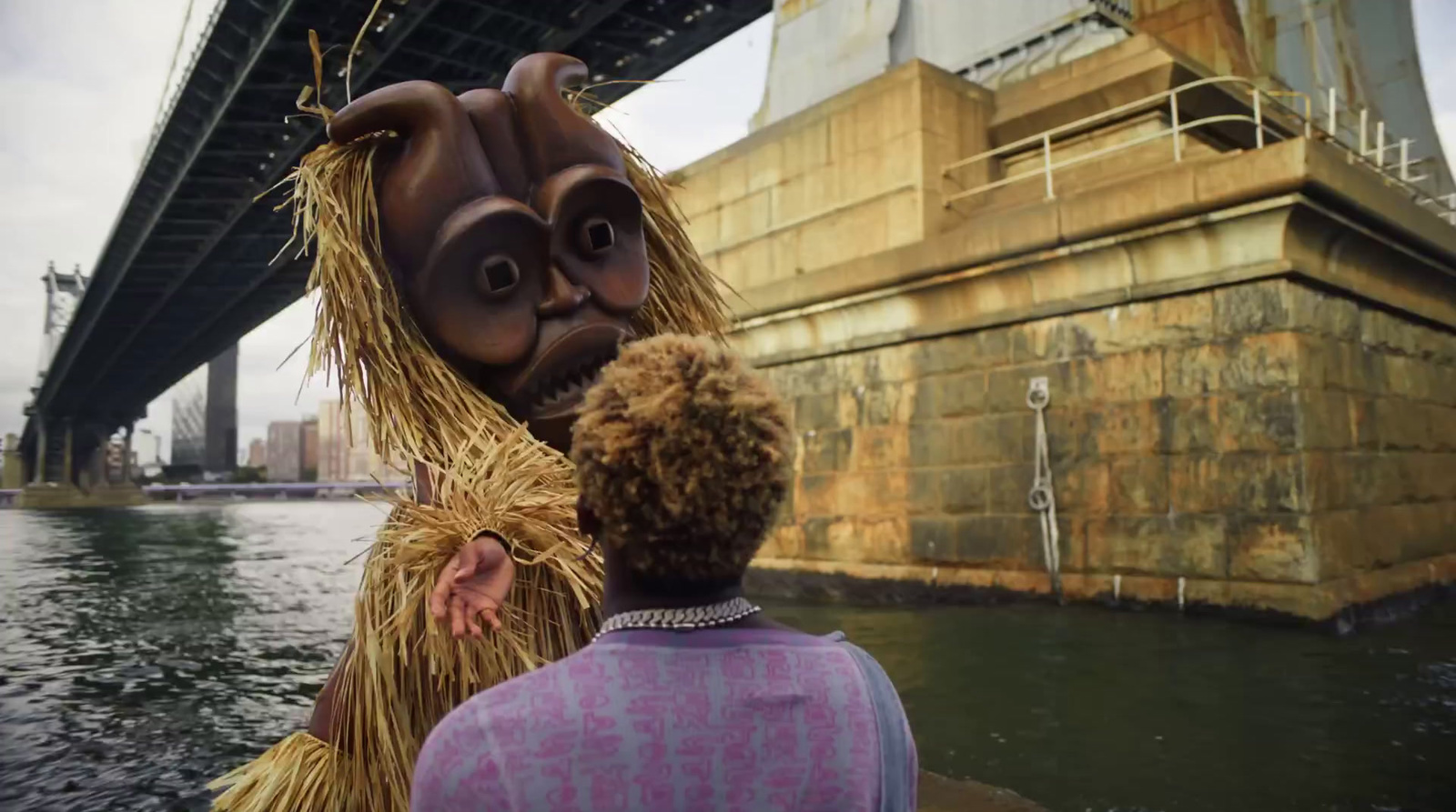 a man standing next to a woman in front of a bridge