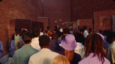 a group of people standing in front of a brick wall