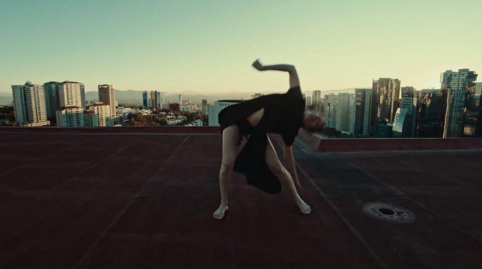 a woman doing a handstand on top of a building