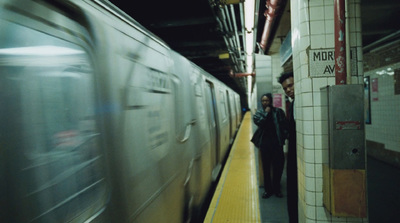 a subway station with a train passing by