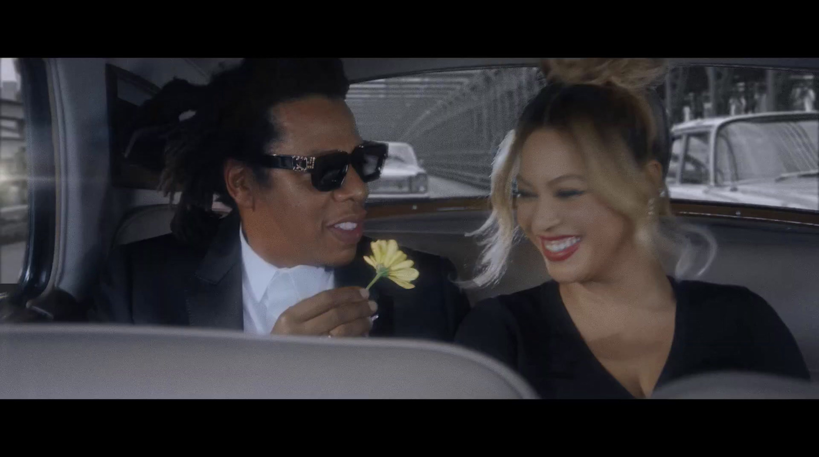 a man and a woman in a car with a flower