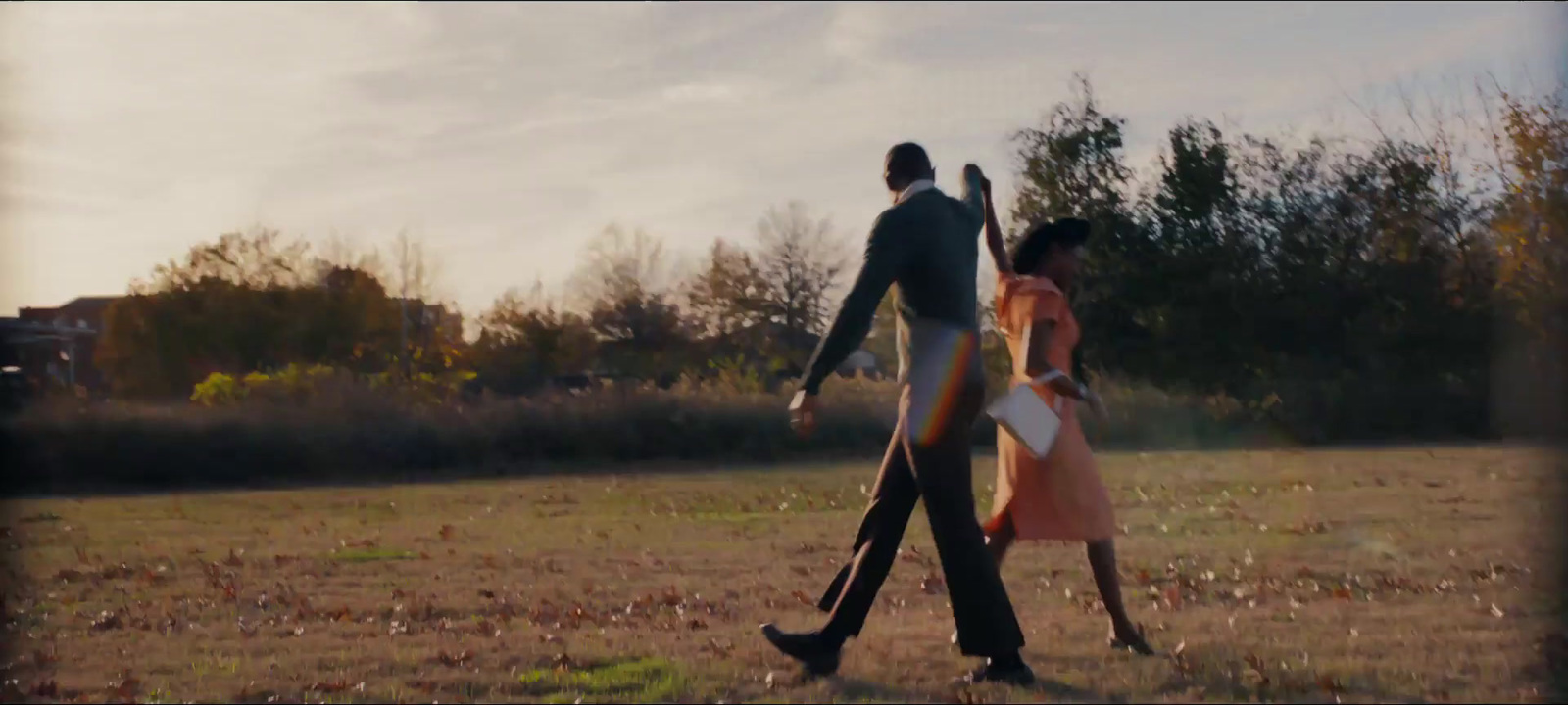 a man and a woman walking in a field