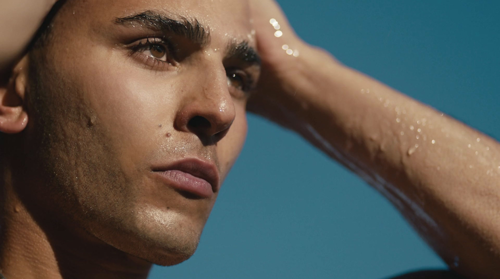 a close up of a man holding his hand to his head