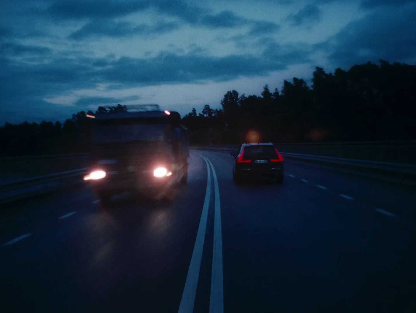 a couple of cars driving down a highway at night