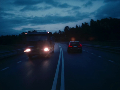 a couple of cars driving down a highway at night