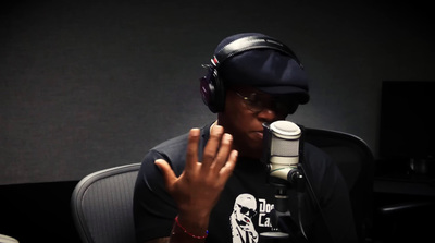 a man with headphones on sitting in front of a microphone