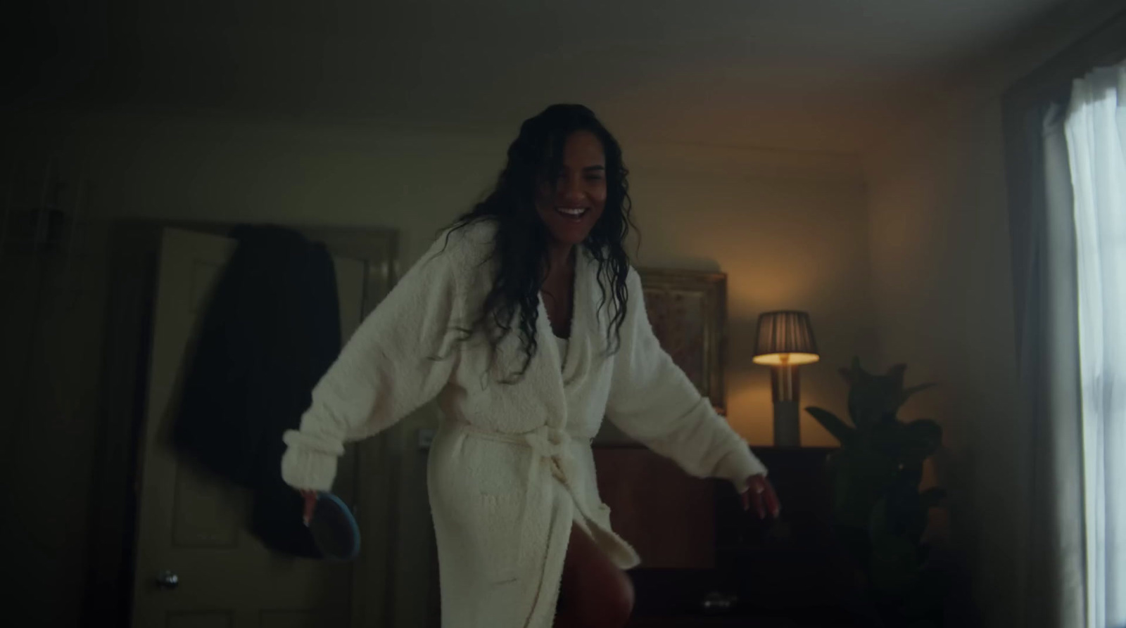 a woman in a bathrobe standing in a room